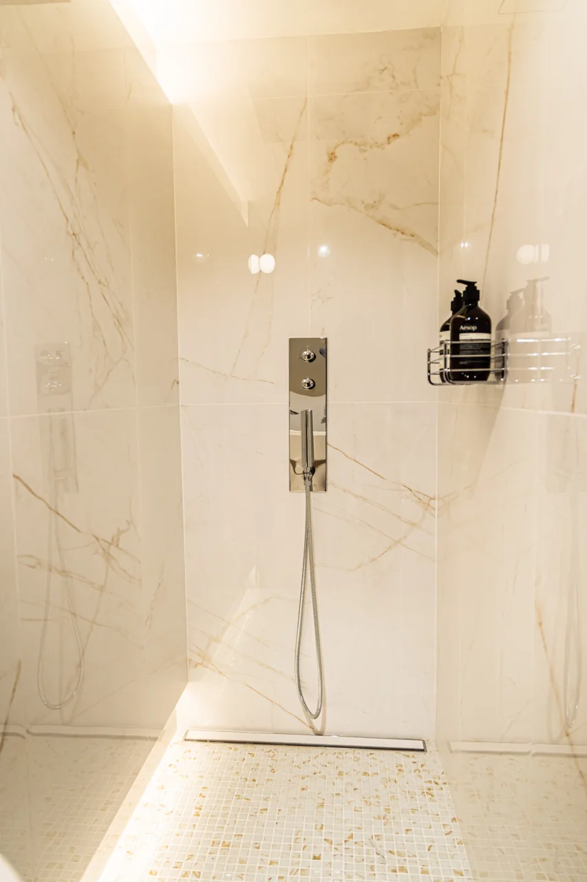 Ducha del club, con paredes claras y productos de aseo.